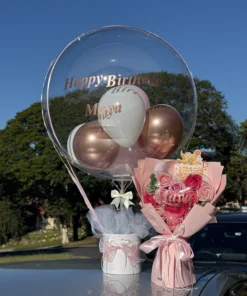 Pink White Balloon Bucket. Birthday celebration with balloons and flowers.
