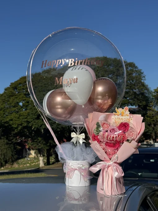 Pink White Balloon Bucket. Birthday celebration with balloons and flowers.